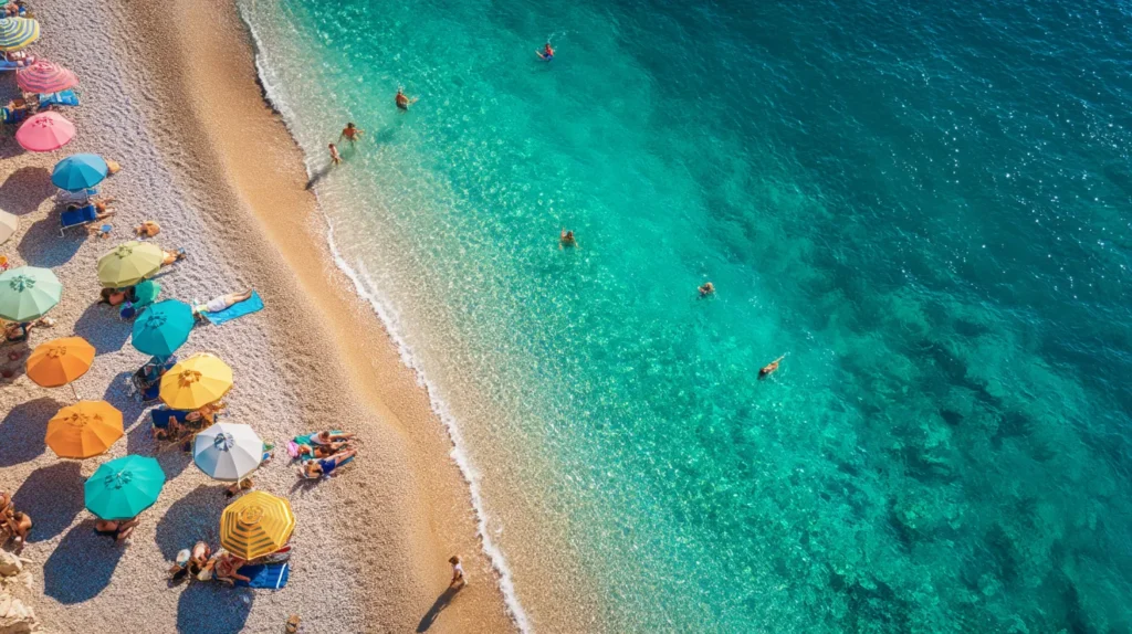 Strand i Grekland med turkost vatten och parasoller, perfekt för en budgetresa.